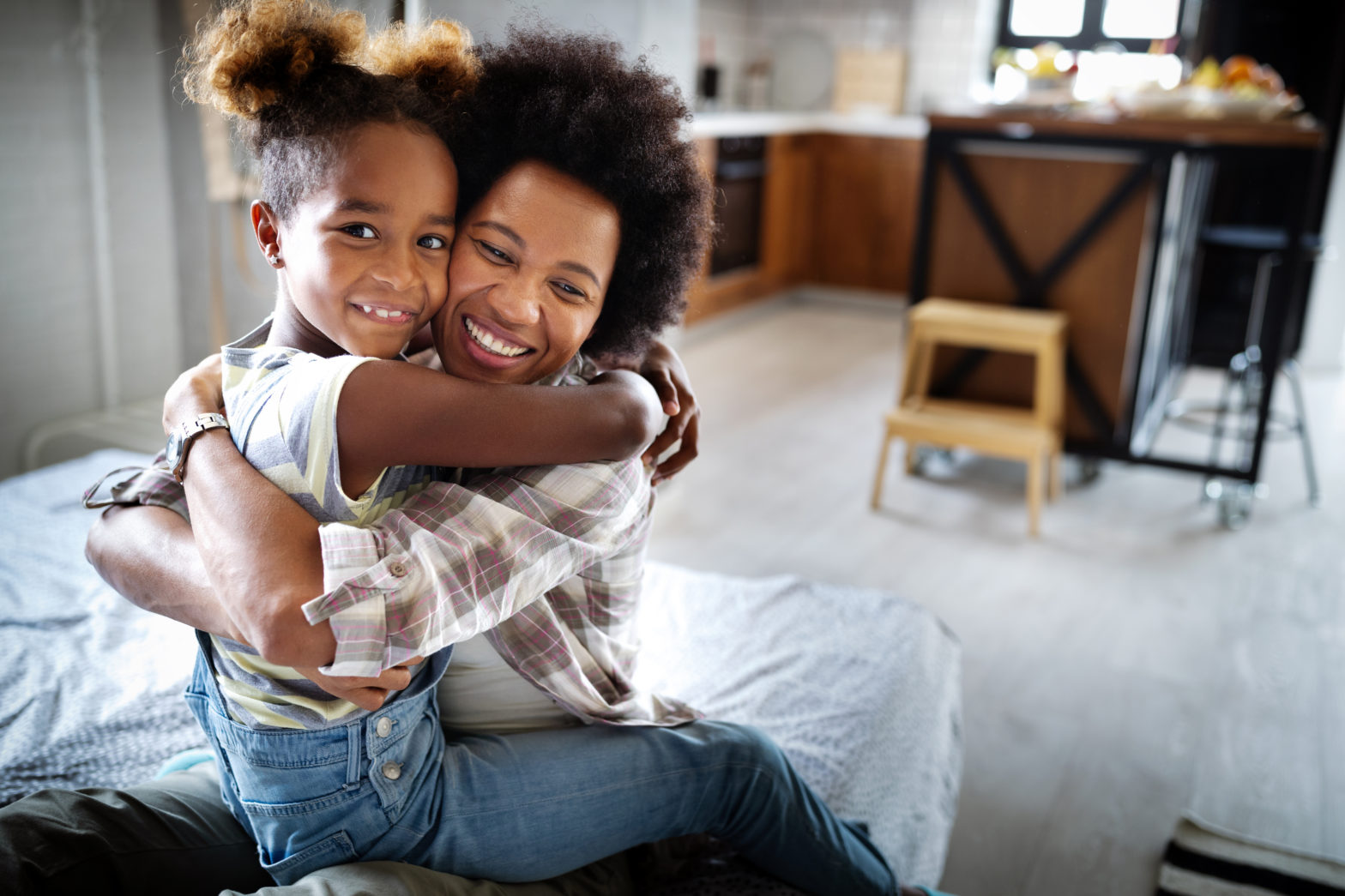 Woman and daughter hugging at home