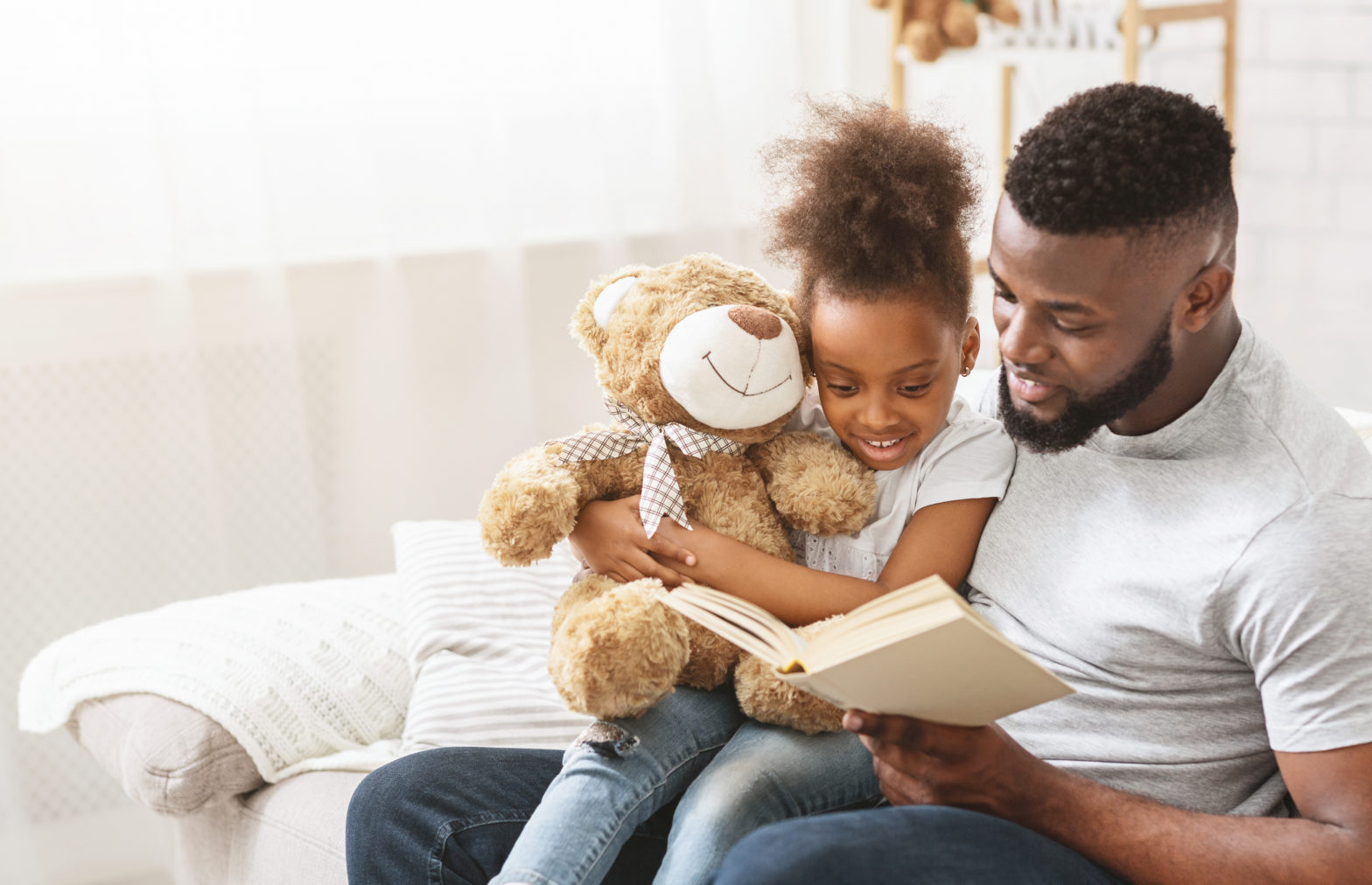 Man and daughter reading a book at home