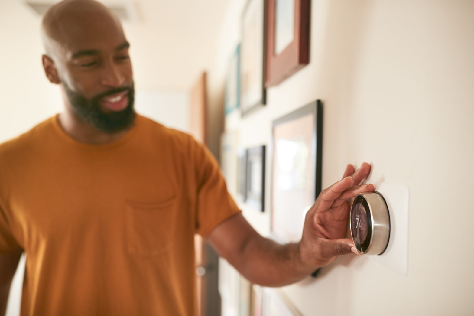 Man adjusting thermostat at home