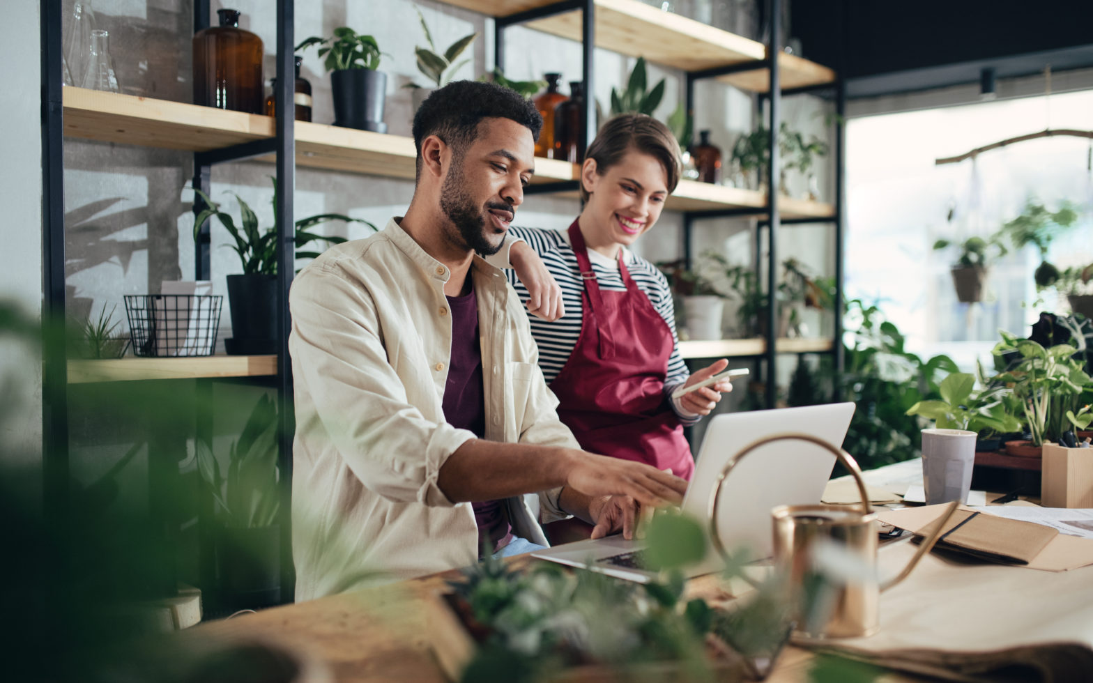 Couple working on laptop in botanical shop