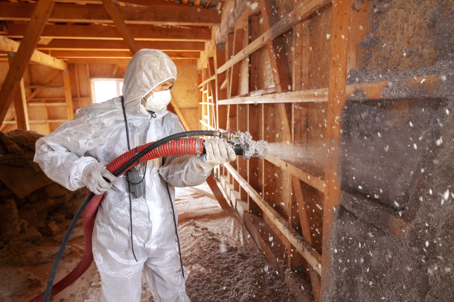 Man spraying insulation at job site